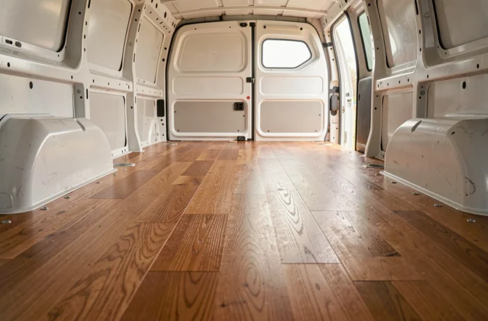 Plancher bois antidérapant installé sur toute la surface de chargement d'un Peugeot Expert, fixations apparentes et grain du bois naturel visibles